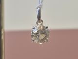 a small diamond pendant hanging from a silver chain