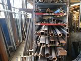 a large pile of metal pipes and pipes in a warehouse