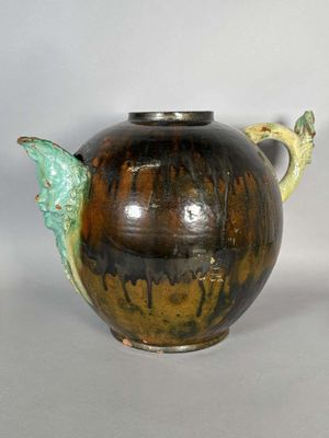 un vase marron et vert orné d'un oiseau