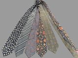 five ties that are tied together on a gray background