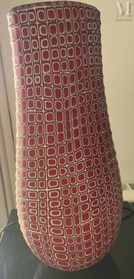 un vase rouge et blanc posé sur une table noire