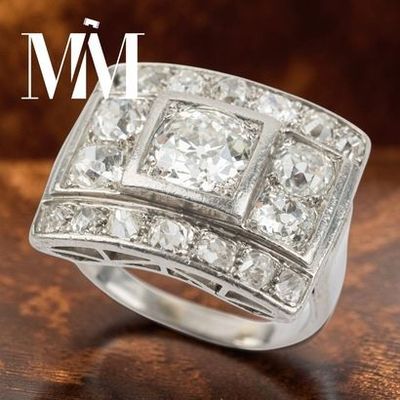 un gros plan d'une bague en diamant posée sur une surface en bois