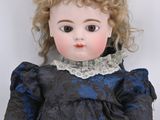a small doll with blonde hair and a blue dress
