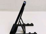 a black tablet on a stand on a white table