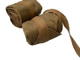 pair of rolled up towels on a white background with a brown ribbon