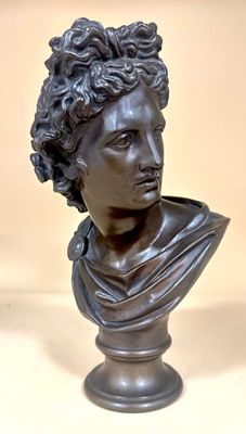 bronze bust of a woman with curly hair on a pedestal