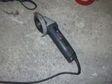un petit outil électrique posé par terre à côté d'une paire de ciseaux
