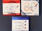 trois boîtes contenant des cartes d'embarquement d'Air France posées sur une table