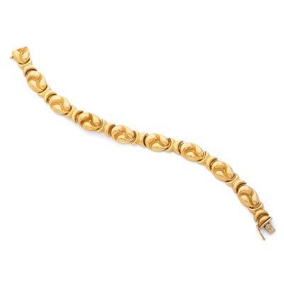 gros plan d'un bracelet en or sur fond blanc