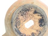 a brown vase with a hole in it on a white surface