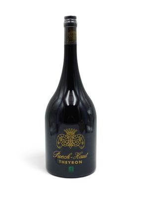 a bottle of red wine sitting on top of a white table