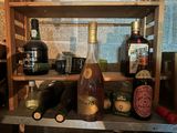 many bottles of alcohol on a shelf in the kitchen