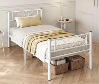 un lit blanc dans une chambre au sol en parquet