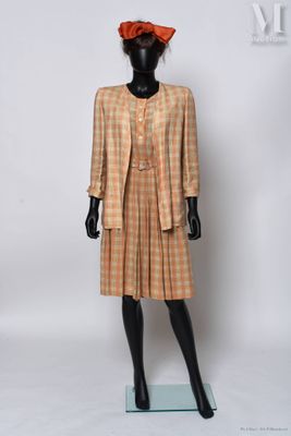 une photo d'un mannequin vêtu d'un costume à carreaux beige et orange