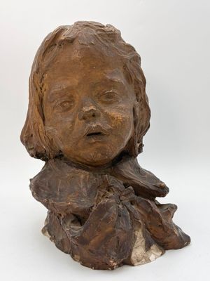 sculpture of a child ' s head on a piece of wood