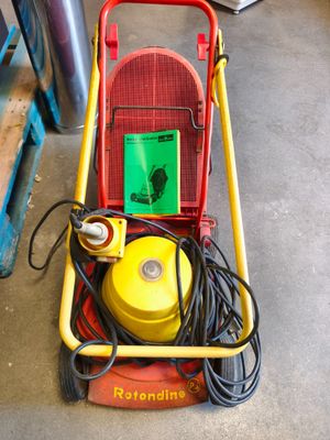 un chariot rouge et jaune muni d'un tuyau jaune et d'un panneau vert
