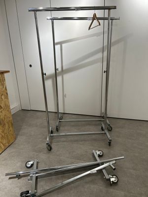 a metal rack with clothes hanging on it in a room