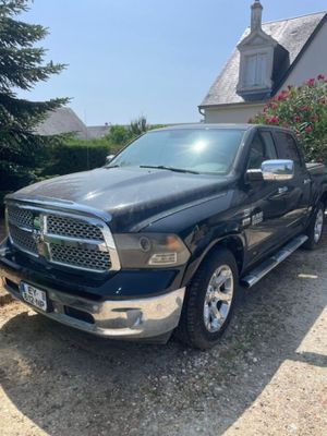 a black ram truck parked in front of a house