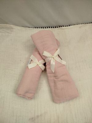 deux serviettes pliées sur un lit, avec un oreiller blanc