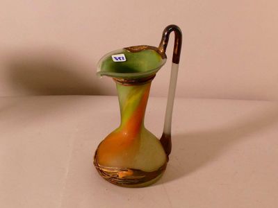 un vase vert et jaune dans lequel se trouve un bâton