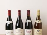 quatre bouteilles de vin sont alignées sur une table en bois
