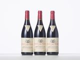 three bottles of red wine sitting on top of a table
