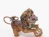 a gold and enamel figurine of a horse pulling a carriage
