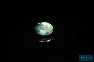 un gros plan d'une pierre de jade verte sur une surface noire