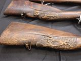three old guns are on a table with a black cloth