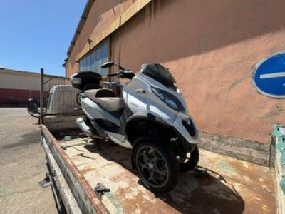 un scooter garé sur une remorque devant un immeuble