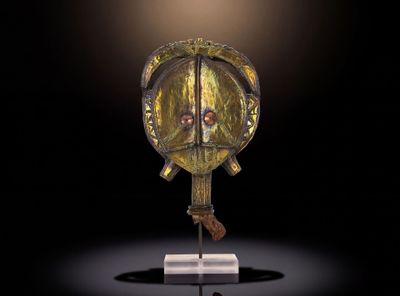 une image représentant un casque doré posé sur un socle