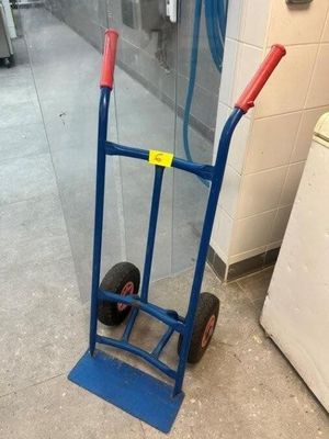 a blue hand truck with a red handle on the floor