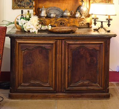 une armoire en bois surmontée d'un miroir, dans une pièce