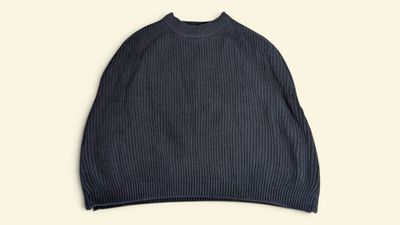 a picture of a black sweater hanging on a hanger