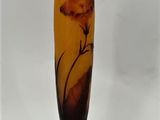 a glass vase with a flower on it sitting on a table
