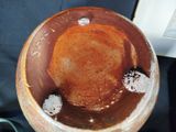 a brown and white bowl sitting on a table next to a book