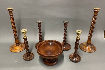 several wooden candlesticks and a bowl on a table