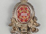un insigne rouge et or orné d'une couronne