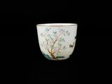 une tasse blanche sur laquelle sont peints un arbre et des oiseaux