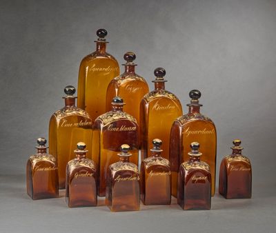 Des bouteilles de différentes tailles et formes sont alignées sur une surface grise.