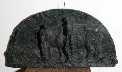 une sculpture représentant un groupe de personnes, posée sur un socle en bois
