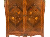 une armoire ancienne en bois ornée de fleurs et de feuilles sur les portes