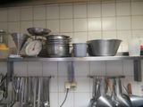 many pots and pans on the shelf in the kitchen
