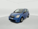 the small blue car is parked in a white room