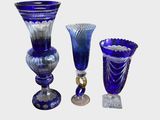 three blue glass vases sitting next to each other