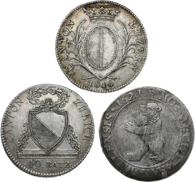 trois pièces d'argent sur lesquelles figurent des armoiries et un bouclier
