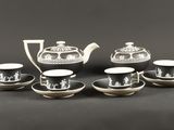un ensemble de tasses et soucoupes noires et blanches posées sur une table