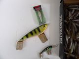 a box of fishing lures sitting on a table next to a box of fish