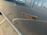 cars parked in a parking lot with a license plate on the hood of a car