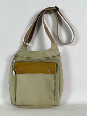 beige and brown purse with a leather strap on a white background